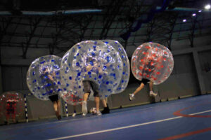 Gracze w dmuchanych kulach podczas meczu bubble football